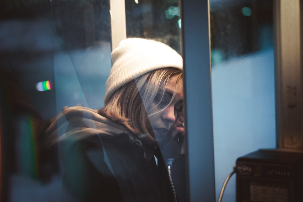 Mujer cansada en cabina telefónica
 Alexandre Croussette 